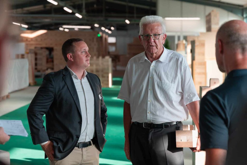 Nachhaltig bauen: Winfried Kretschmann zu Besuch im Holzmassivbau Stammwerk der TRIQBRIQ AG in Tübingen