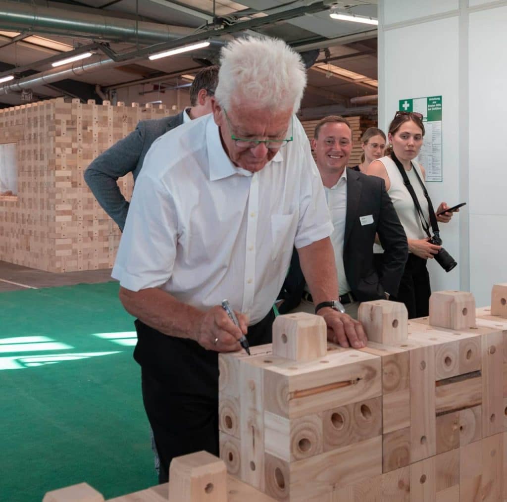 Nachhaltig bauen: Winfried Kretschmann zu Besuch im Holzmassivbau Stammwerk der TRIQBRIQ AG in Tübingen